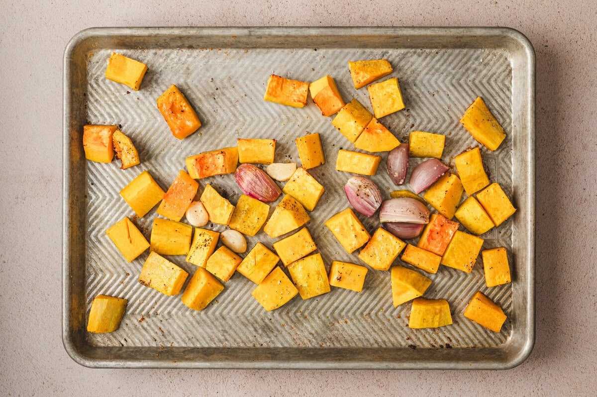 Roasted butternut squash with shallots and garlic on a sheet pan